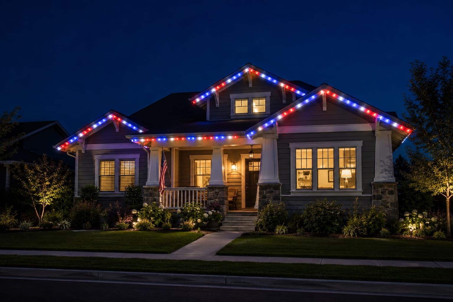 Craftsman home lit red, white, and blue for the Fourth of July